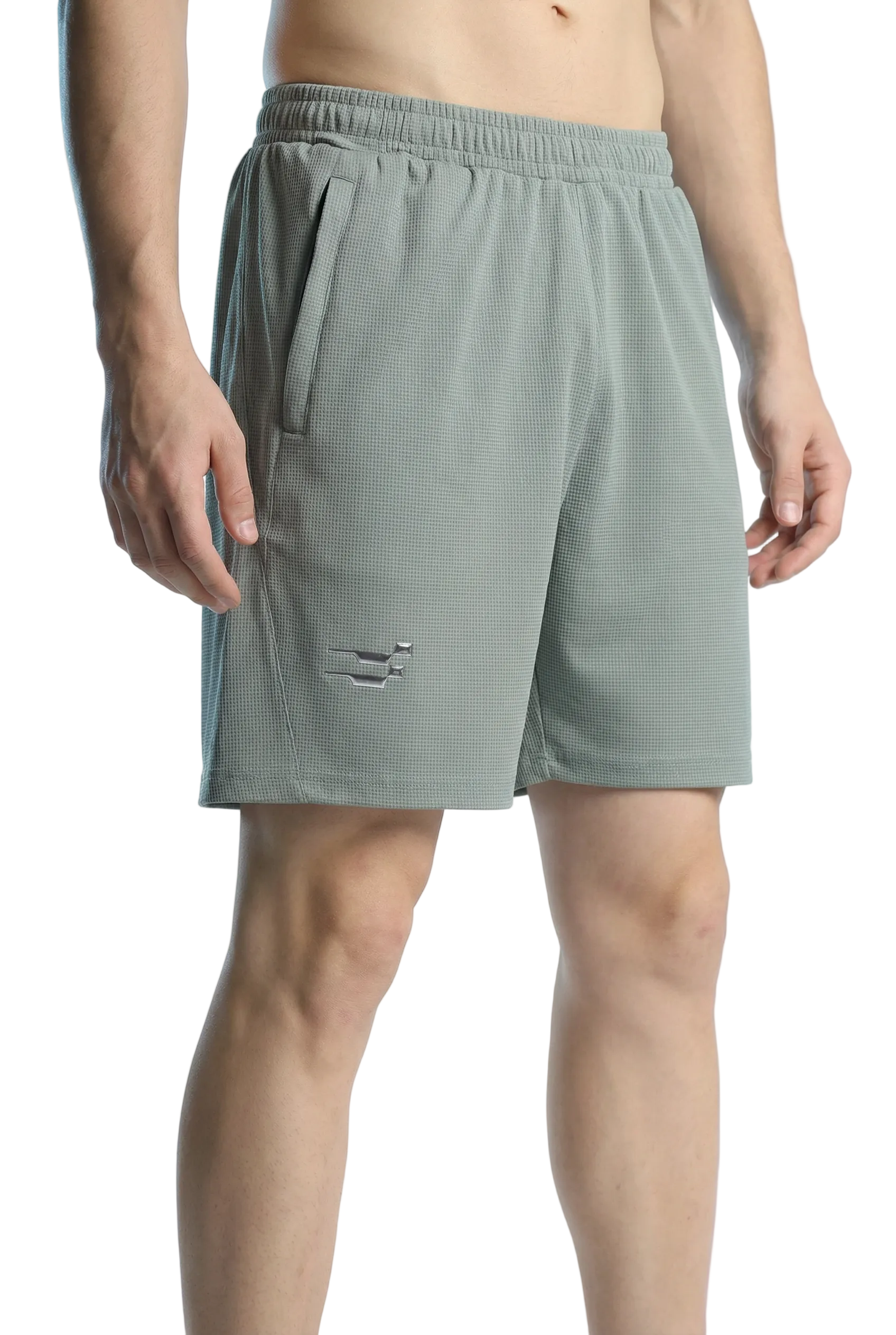 Person wearing light green shorts on a plain background