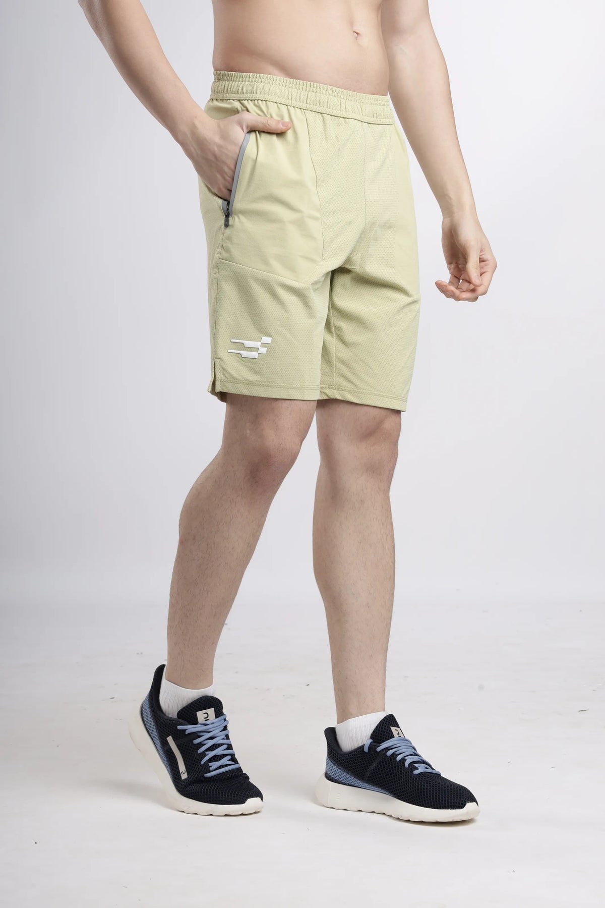 AirWave Performance Shorts in sand, angled front view with a hand in the zip pocket