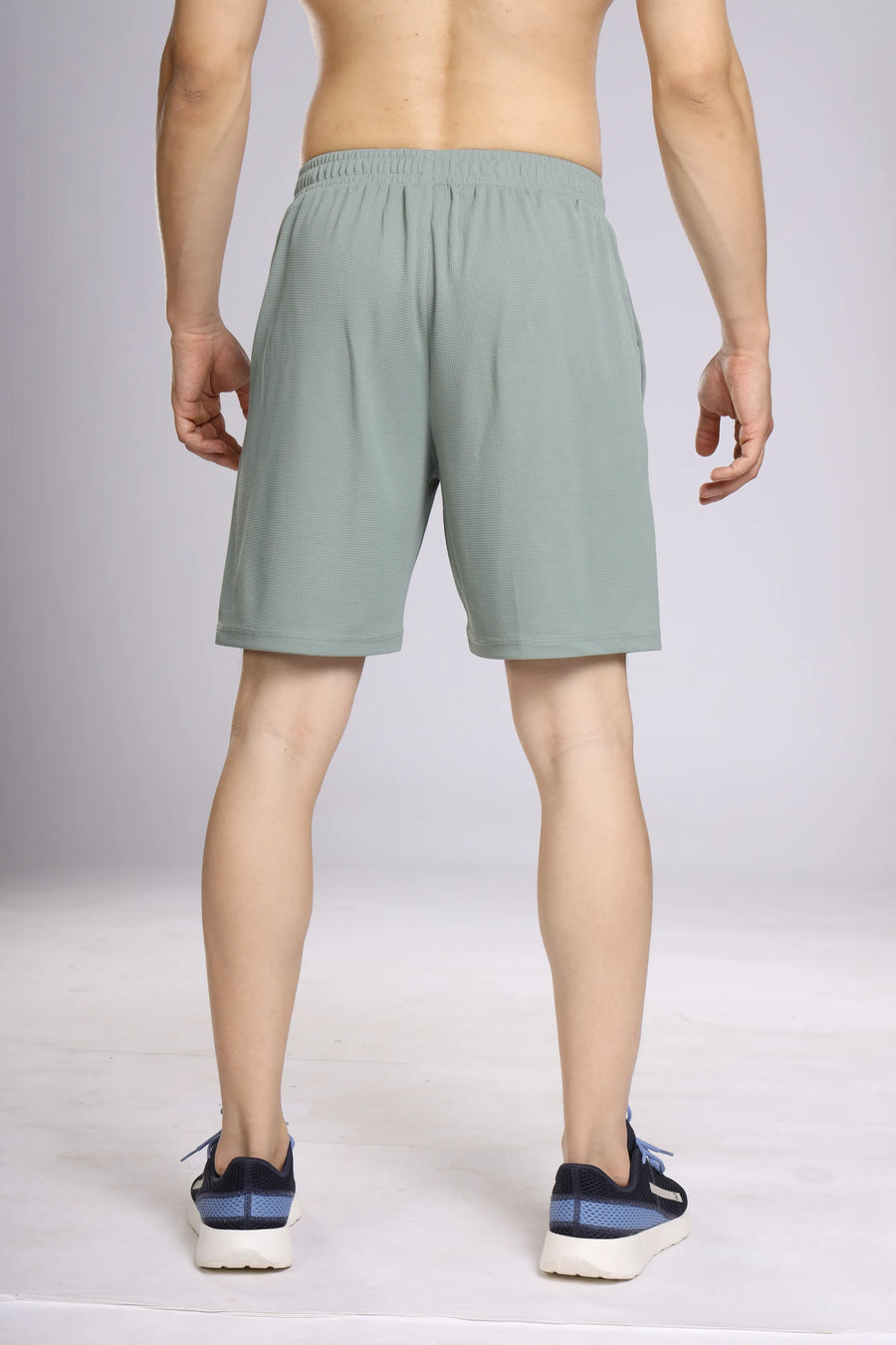 Club Performance Shorts in forest green, back view on a model showing the elastic waistband and plain back