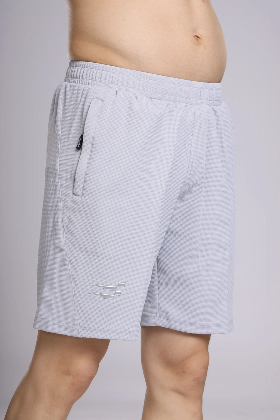 Club Performance Shorts in silver haze, close-up of the waistband, zip side pocket, waffle-textured fabric and leg logo