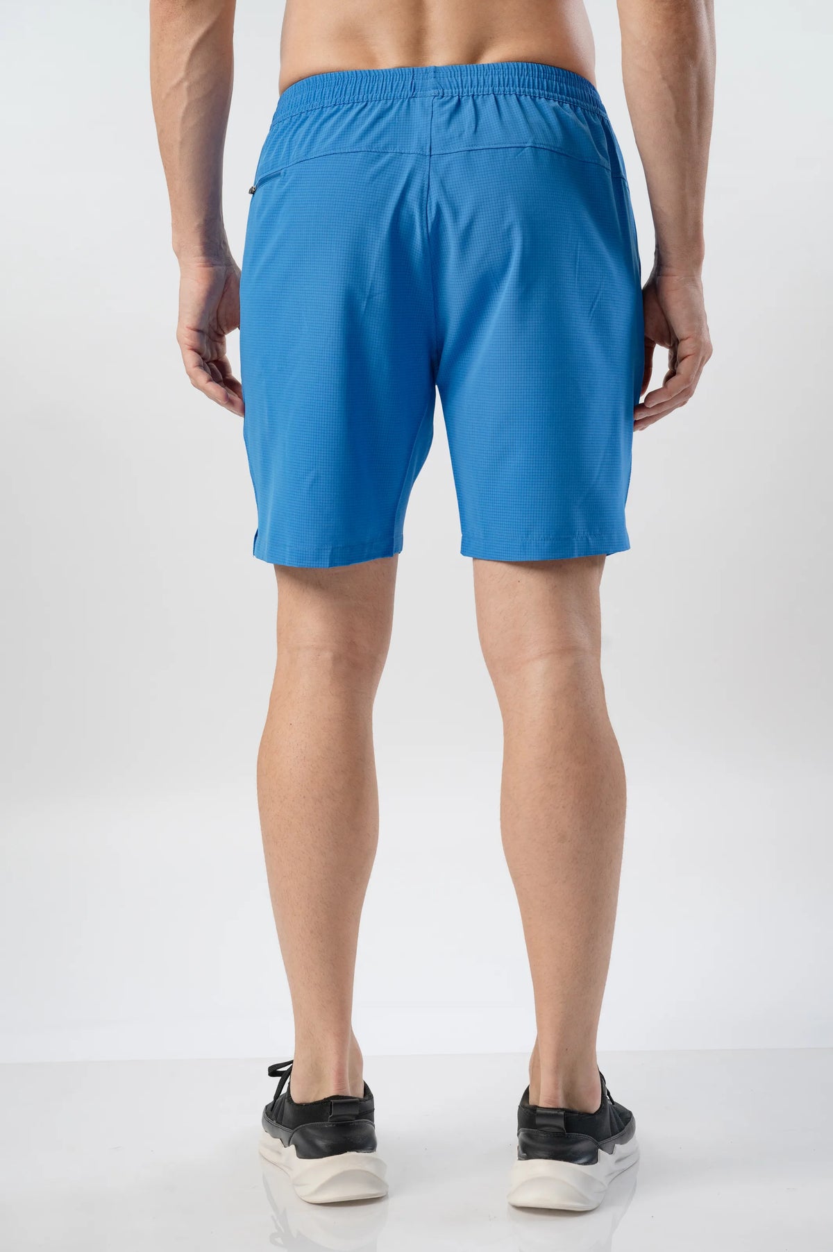 Fast-Track Running Shorts in bright cobalt, back view on a model showing the waistband and seam detail