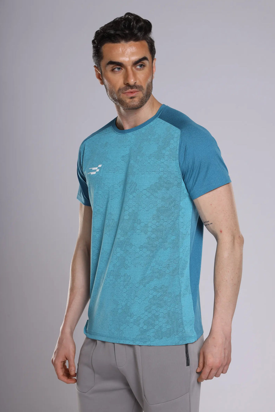 Fit-Gear Octagon T-Shirt in teal, three-quarter view on a model showing the contrast raglan sleeves