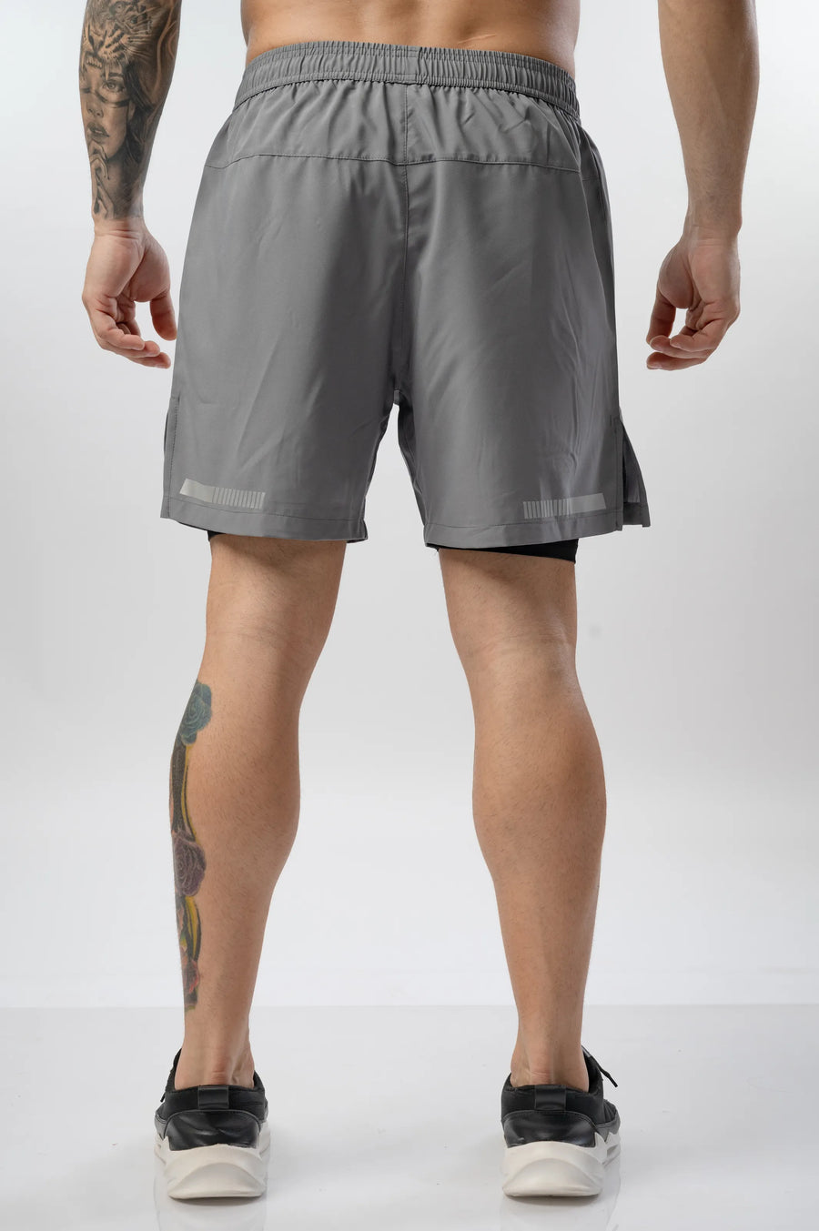 Intense Compression Shorts in grey, back view showing the reflective hem strips and black inner liner