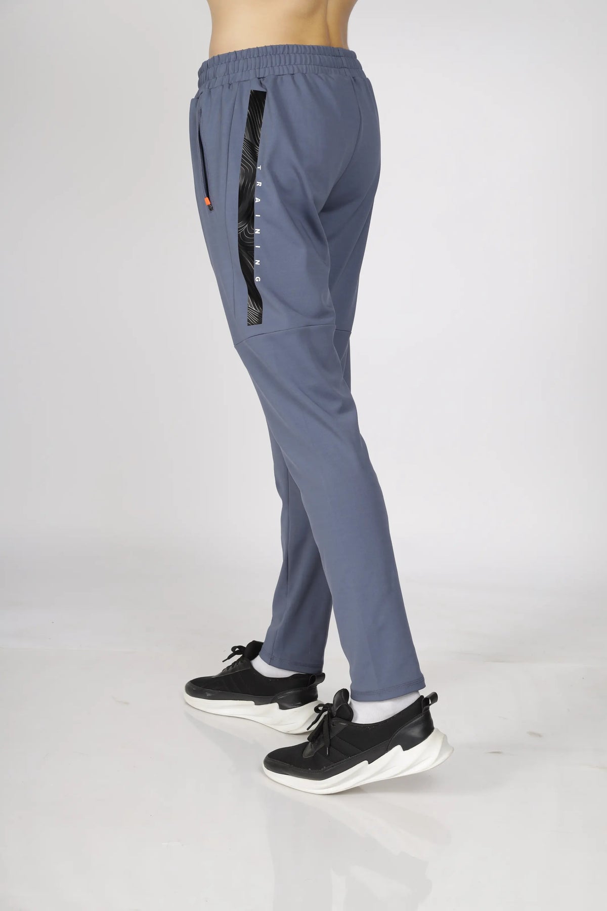 Max-Out Training Track Pant in grey, side view on a model mid-stride