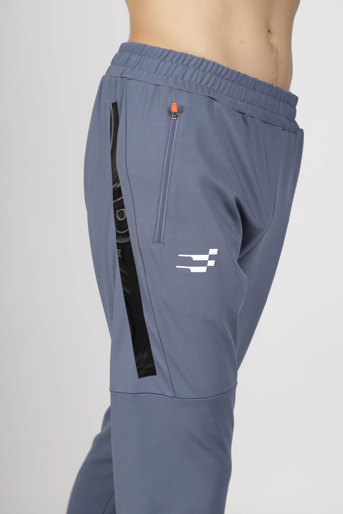 Max-Out Training Track Pant in grey, close-up of the zip side pocket, black side panel and white logo