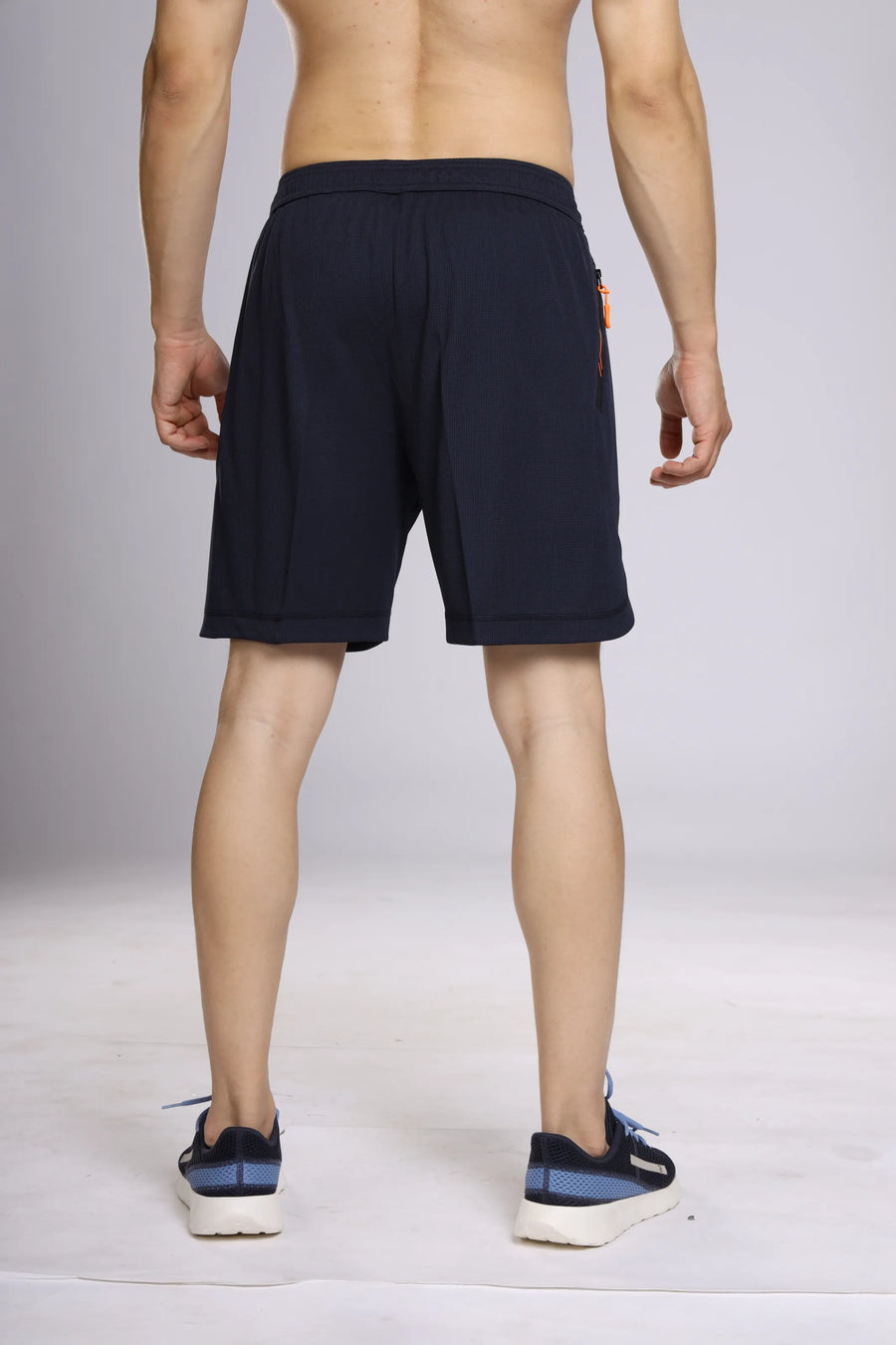 Motion-Tech Running Shorts in navy, back view on a model showing the waistband and straight hem