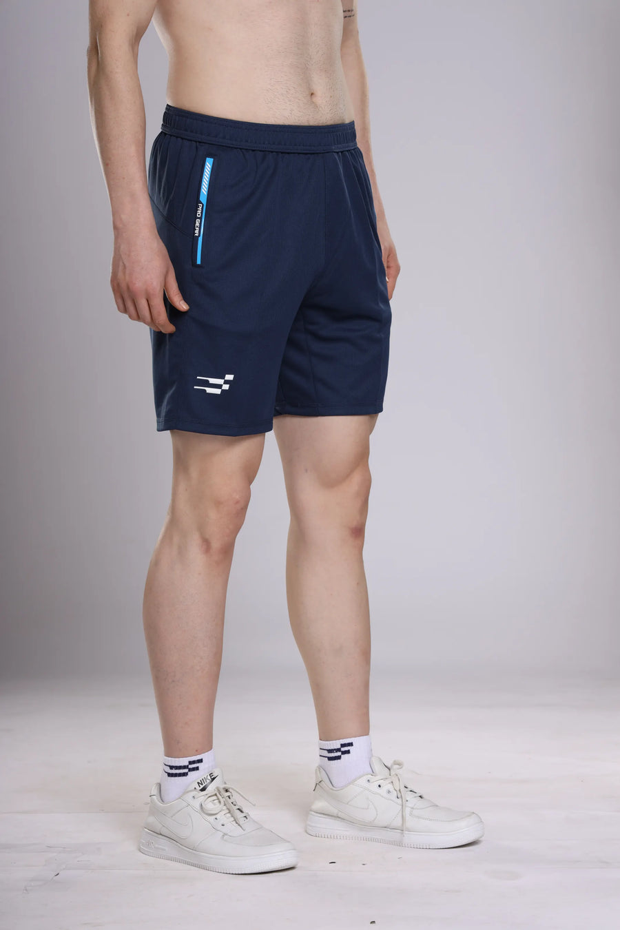Pro-Gear Performance Shorts in navy, side view on a model showing the white logo and blue zip pocket