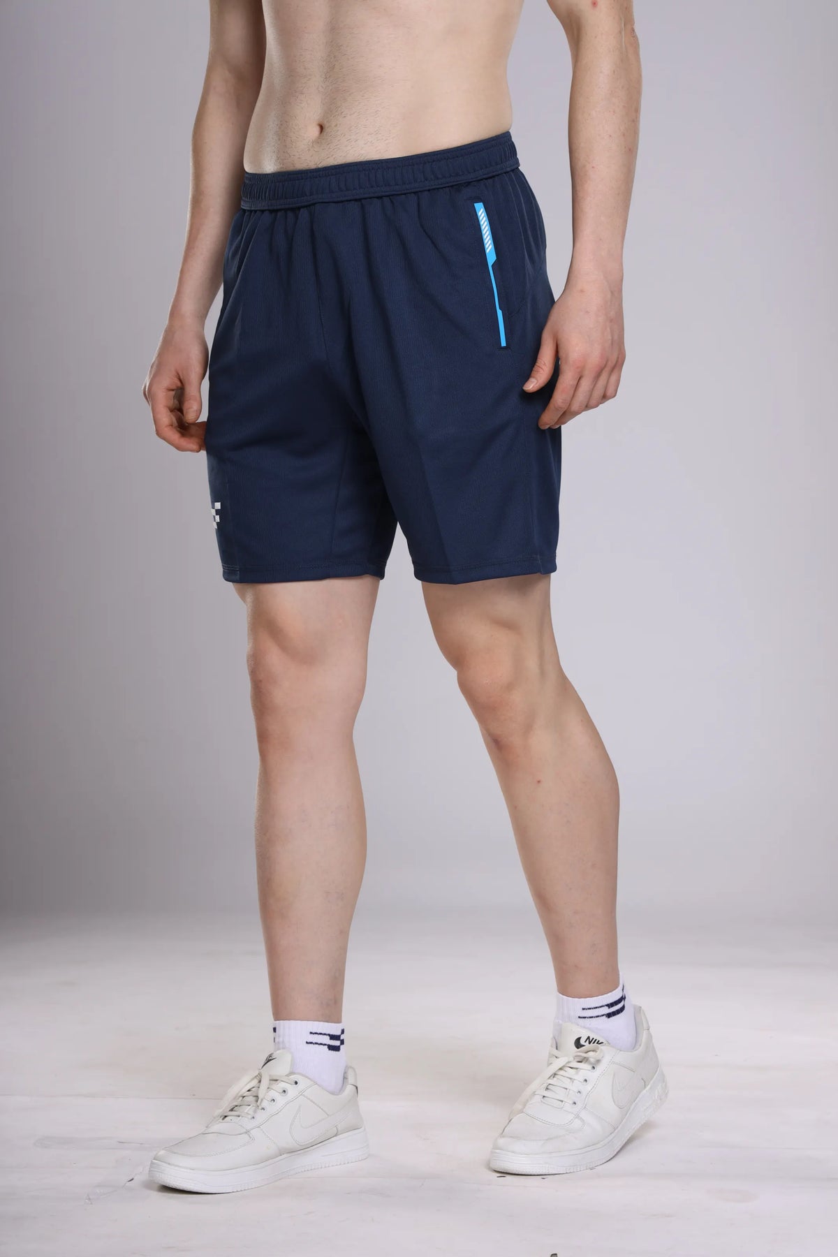 Pro-Gear Performance Shorts in navy, angled view on a model showing the blue zip pocket tape