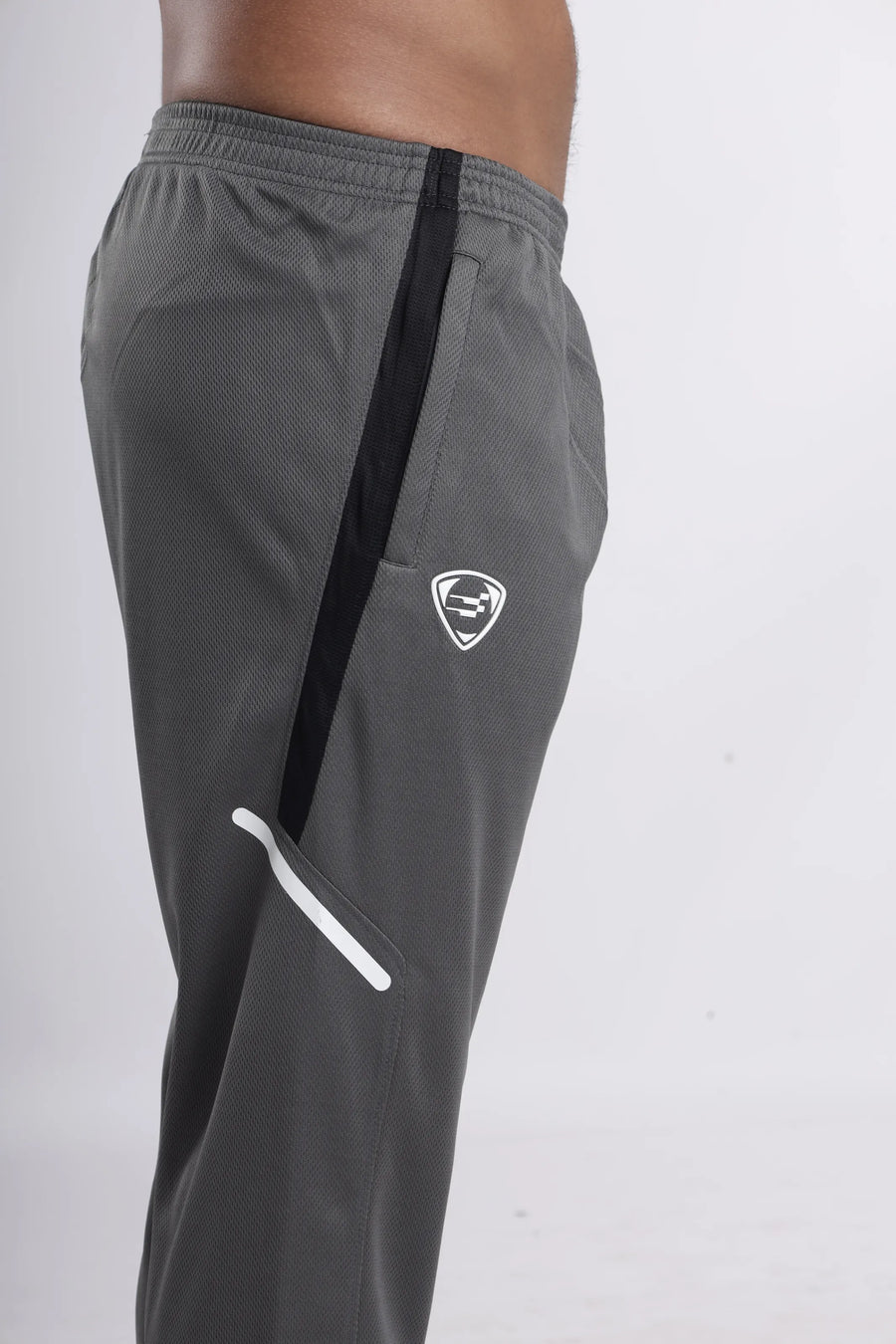 ProSwift Performance Track Pant in grey, close-up of the side with the black stripe, shield logo and white zip trim