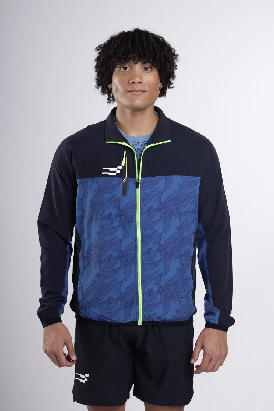 Quantum Performance Track Top in navy, front view on a model with blue camo front panel and lime zip