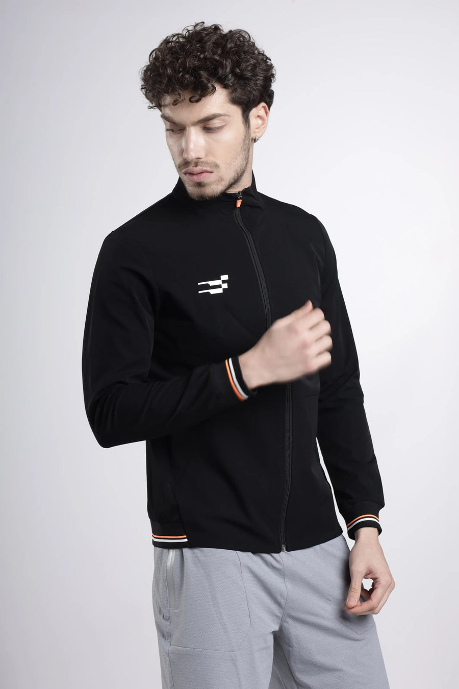 Tech-Shell Performance Track Top in black, three-quarter view on a model showing the striped cuffs and hem
