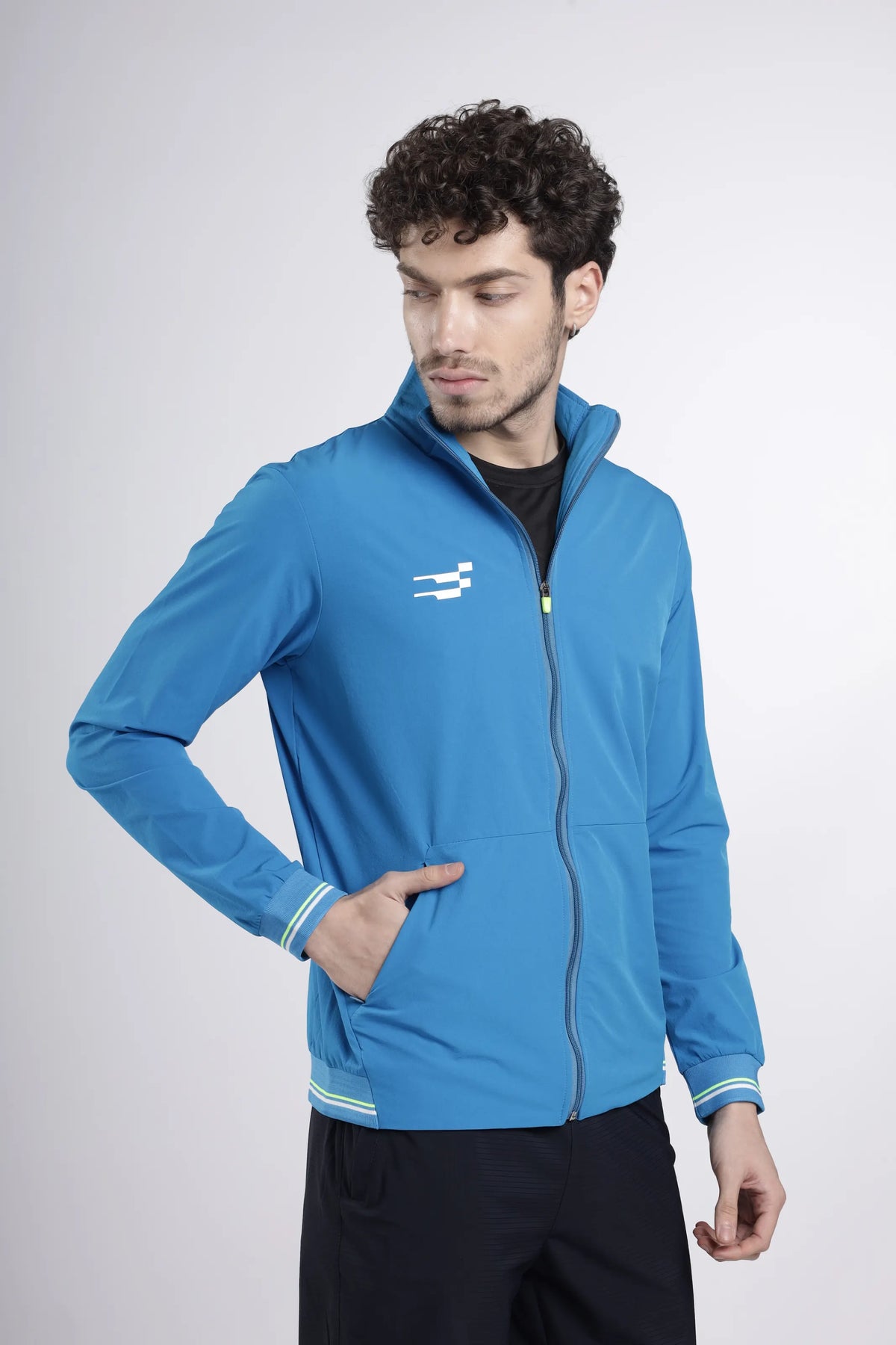 Tech-Shell Performance Track-Top in blue, front view on a model with one hand in the pocket, showing the high collar